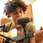 Musician performing with the MV88 microphone in a bright studio environment.