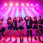 Blackpink news showcasing an energetic concert performance with vibrant stage lights and stylish outfits.