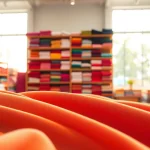 Bekijk de kleurrijke texturen van poplin stof in een goed verlichte showroom.
